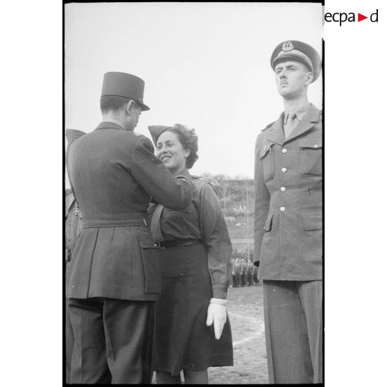 Le général de corps d'armée Philippe Leclerc remet la Croix de guerre à la Rochambelle Ghislaine Bechman. A ses côtés, l'enseigne de vaisseau Philippe de Gaulle. [description provisoire]