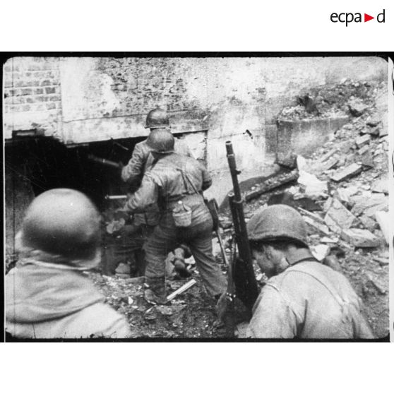 Les fantassins américains fouillent les décombres. [description provisoire]
