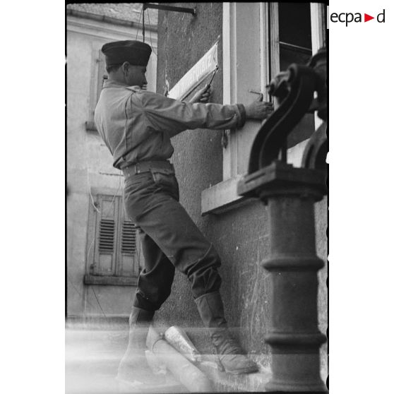 Un soldat démonte la plaque "Adolf Hitler Platz" à Pfortz. [description provisoire]