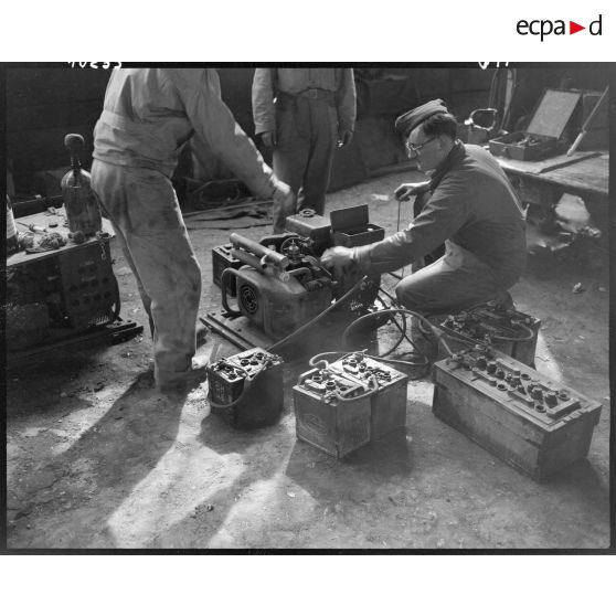 Rechargement de batteries de véhicules dans l'atelier de réparation automobile de la compagnie mixte de transmissions 97/84 de la 2e division blindée (2e DB).