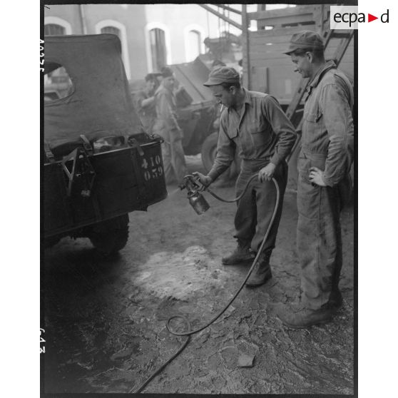 Mise en peinture au pistolet d'une caisse de véhicule dans l'atelier de réparation automobile de la compagnie mixte de transmissions 97/84 de la 2e division blindée (2e DB).