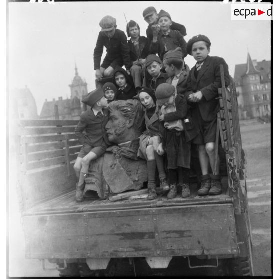 Des enfants entourent la statue du général Rapp. [description provisoire]