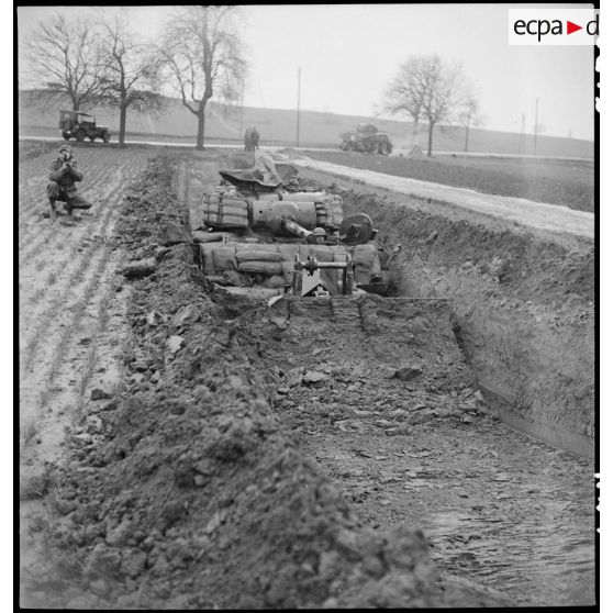 Un char Sherman Dozer américain creuse une tranchée. [description provisoire]