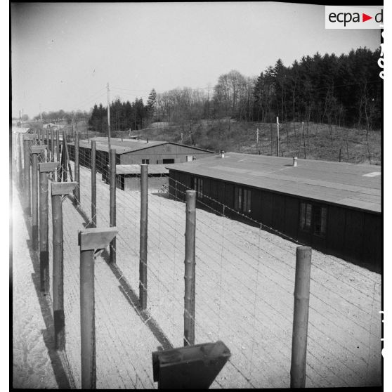 Plan en plongée sur les baraquements et la double enceinte de barbelés encerclant le camp de Vaihingen. [description provisoire]