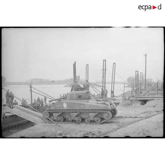 Dans le secteur de la 2e DIM à Germersheim, le char Sherman Loup II, appartenant au 2e escadron du 1er cuirassiers, s'apprête à franchir le Rhin sur une portière. [description provisoire]