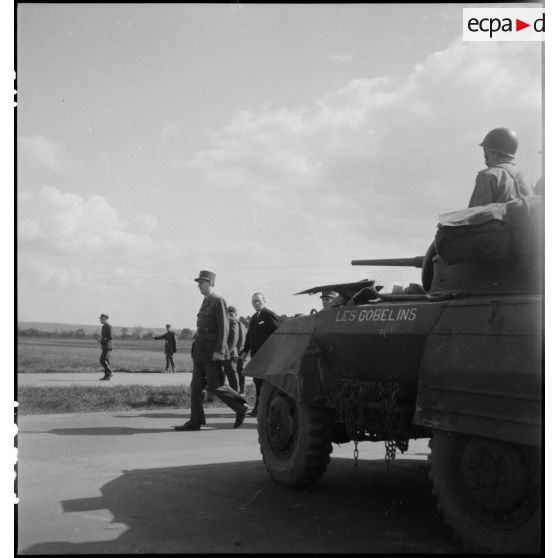 Le général de Gaulle passe les troupes motorisées en revue. [description provisoire]