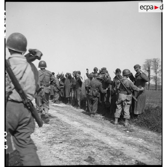 Des prisonniers allemands sont fouillés par des hommes de la 2e division blindée (2e DB) et des Forces françaises de l'Ouest  (FFO) dans le secteur de Royan, sur la route départementale entre Saujon et la La Tremblade.