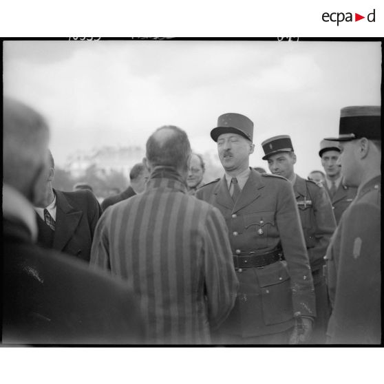Le général de corps d'armée Pierre Koenig, gouverneur militaire de Paris, s'entretient avec un déporté politique à l'issue d'une cérémonie de ravivage de la flamme sur la tombe du Soldat inconnu.