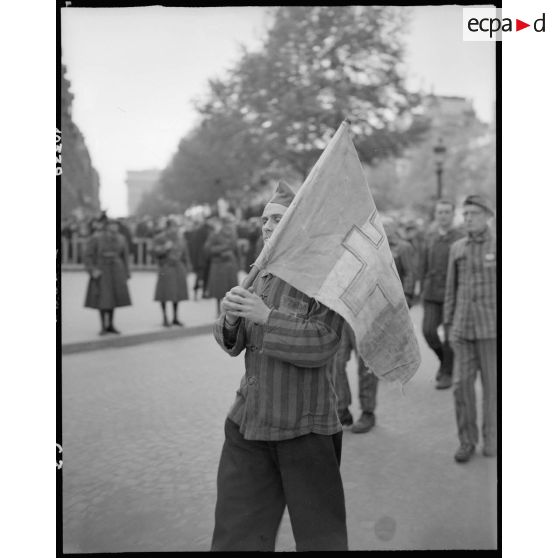 Des déportés politiques quittent l'Arc de Triomphe à l'issue d'une cérémonie de ravivage de la flamme sur la tombe du Soldat inconnu.