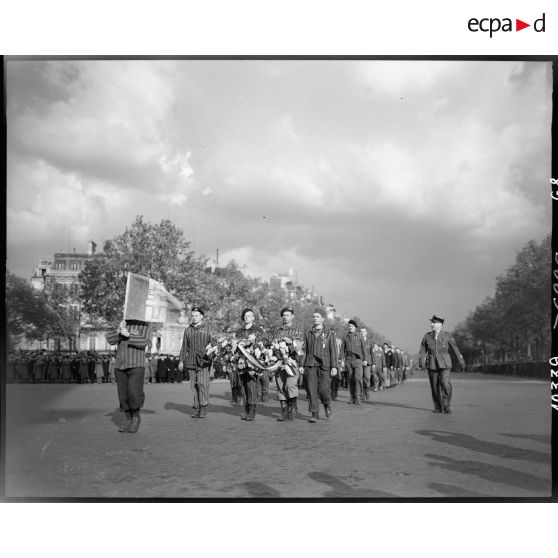 Des déportés politiques arrivent en ordre serré à l'Arc de Triomphe pour participer au ravivage de la flamme sur la tombe du Soldat inconnu.