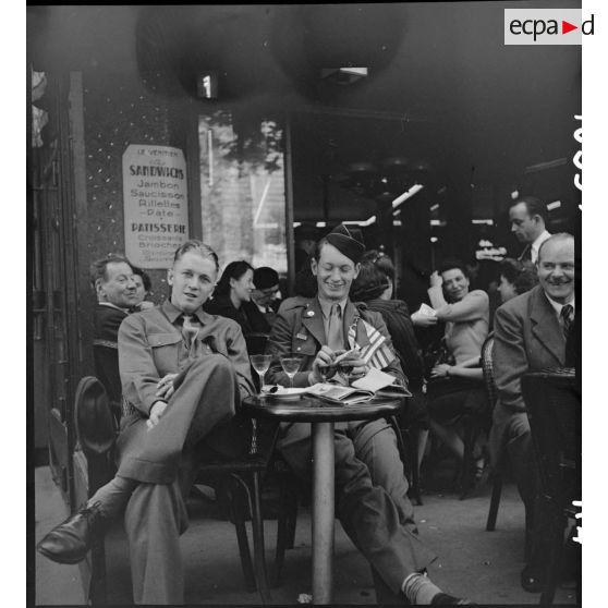 Soldats américains attablés à la terrasse d'un café à Paris.