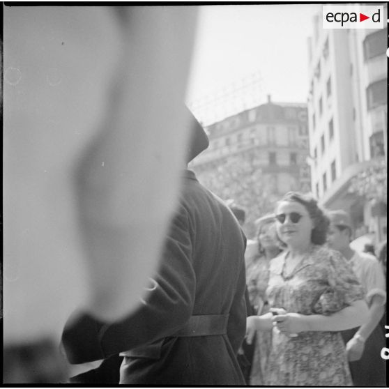 Un soldat français ou américain fraternise avec des parisiennes dans une rue de la capitale.