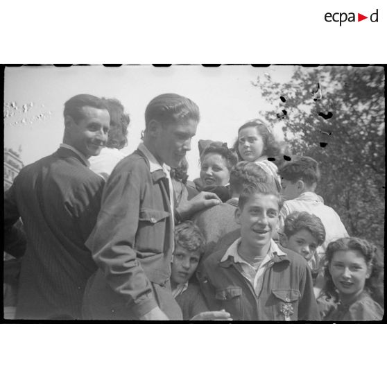 Population civile et militaires américains embarqués sur des véhicules circulant sur les Champs-Elysées.