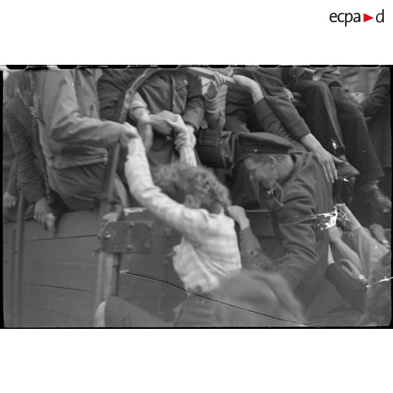 Population civile et militaires américains embarqués sur des véhicules circulant sur les Champs-Elysées.