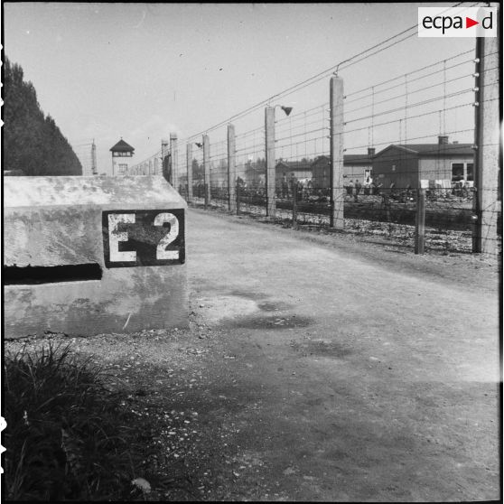 L'enceinte barbelée et des baraquements du camp de concentration de Dachau libéré.