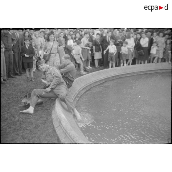 Soldats américains prenant un bain de pieds dans un bassin à Paris.