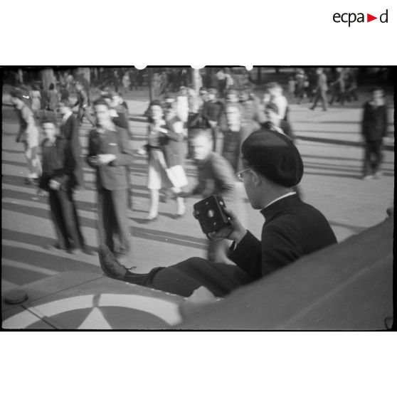 Prêtre embarqué sur un véhicule militaire léger américain circulant dans Paris.