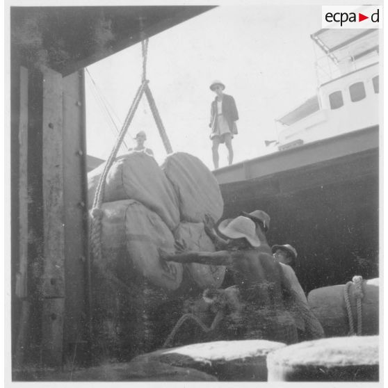 23 à 25 Déchargement de ballots de coton dans le port. [description provisoire]