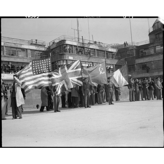 Des détachements et porte-drapeaux des nations alliées attendent l'arrivée de Jules Carron, millionième prisonnier français libéré rapatrié, sur l'aéroport du Bourget.