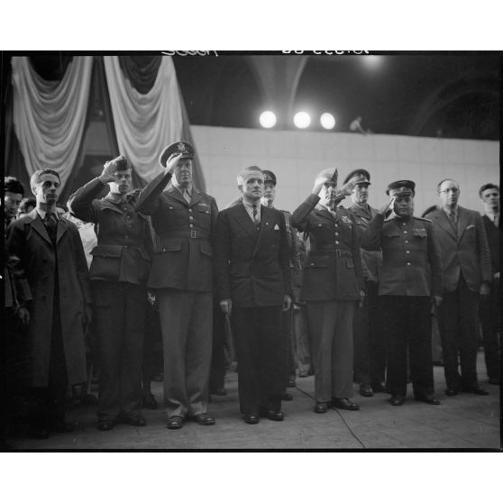 En présence de Henri Frenay, ministre des prisonniers, déportés et réfugiés, Jules Carron, millionième prisonnier français libéré rapatrié en France, salue lors de l'exécution des hymnes nationaux des nations alliées.