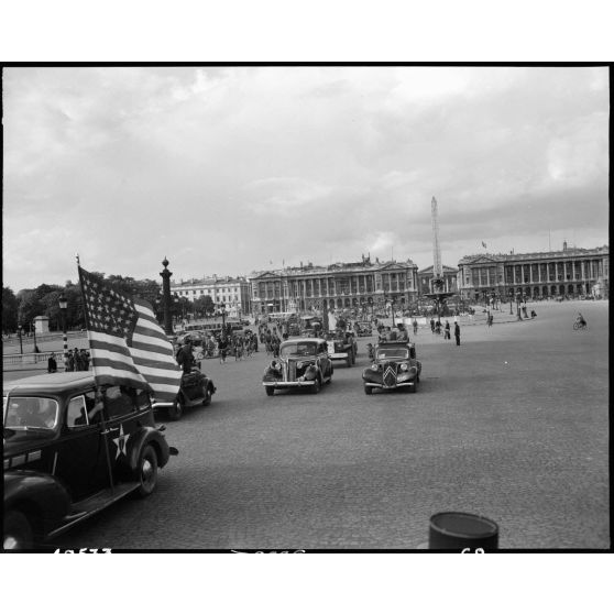 Jules Carron, millionième prisonnier français libéré rapatrié, circule Place de la Concorde à bord d'un Dodge command car de l'armée américaine.