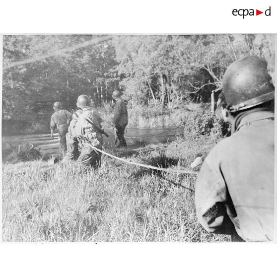 Soldats américains passant un cours d'eau dans la Manche lors de la progression de la IIIe armée américaine en Normandie.