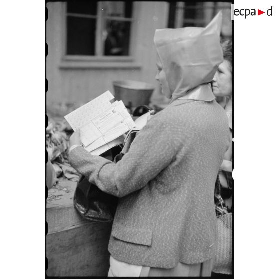 Une habitante de Stuttgart présente des tickets de rationnement.