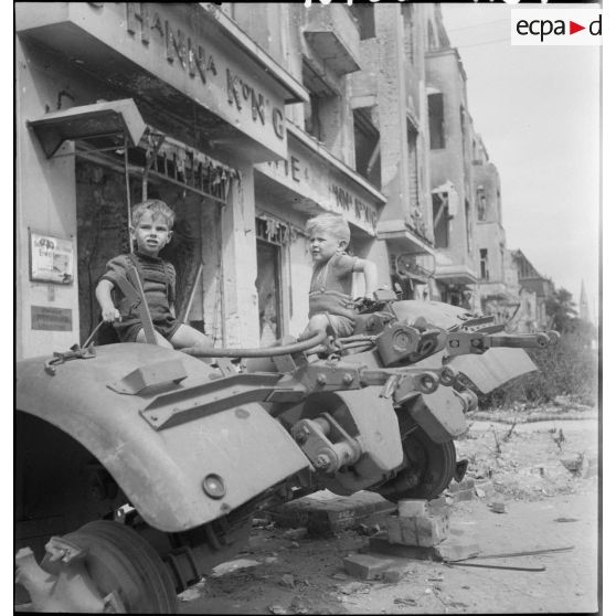 Des enfants jouent sur l'épave d'un canon antiaérien allemand.