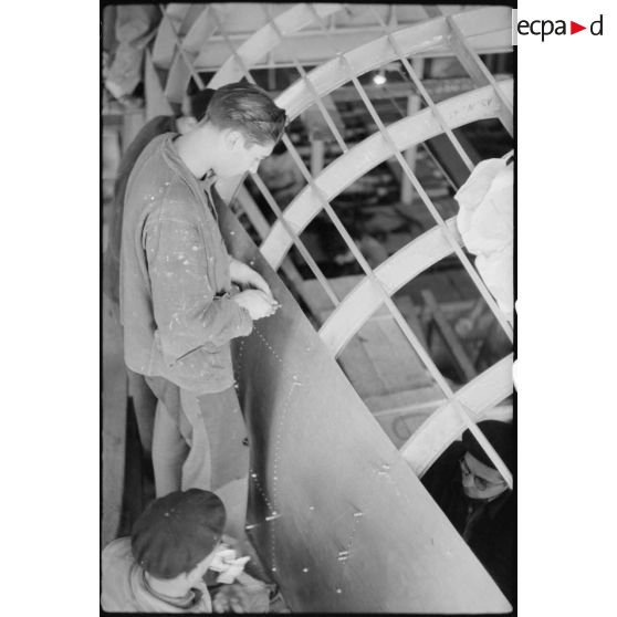 Rivetage de plaques de duralium sur la coque.