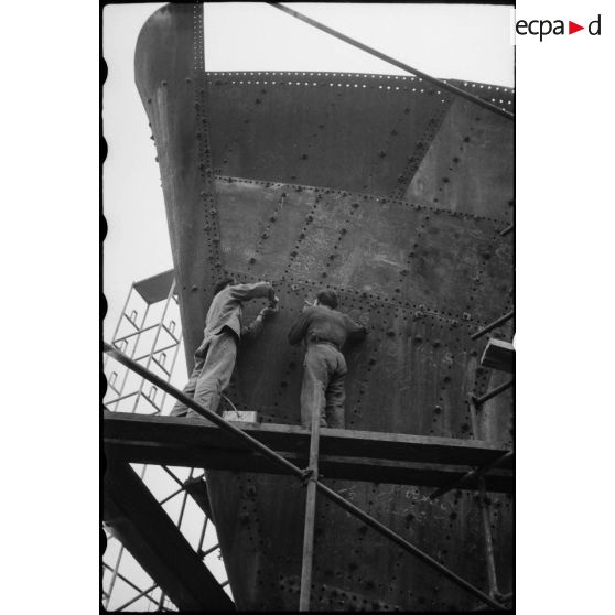 Rivetage de la coque d'un cargo.
