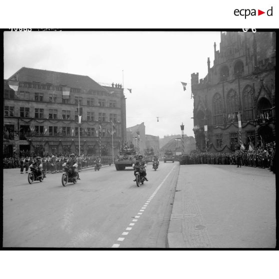 Défilé de blindés passant devant la tribune à Sarrebruck : M3 Stuart et convoi de motocyclettes.