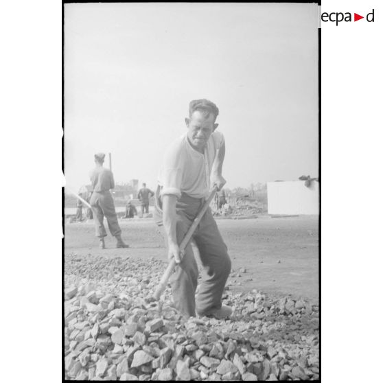 Un homme déblayant les débris de la ville en ruines.