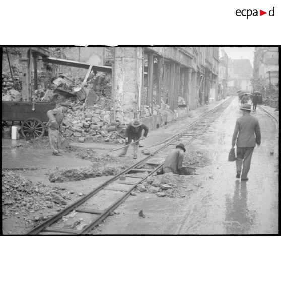 A  Trèves, la population civile nettoie les débris engendrés par la destruction de la ville.