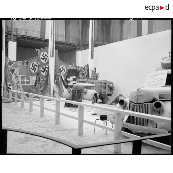 Camion et fourgonnette Ford sur fond de drapeaux nazis.