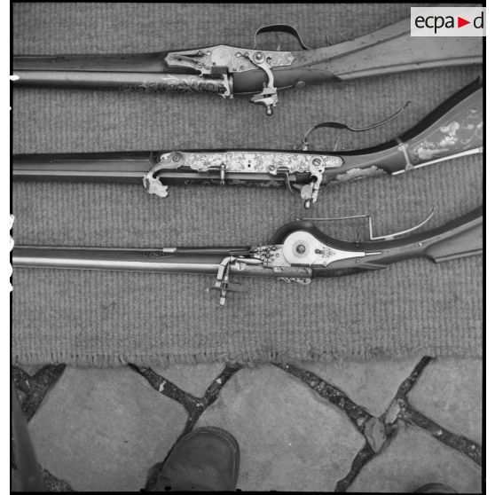 Détail des crosses de trois fusils anciens.