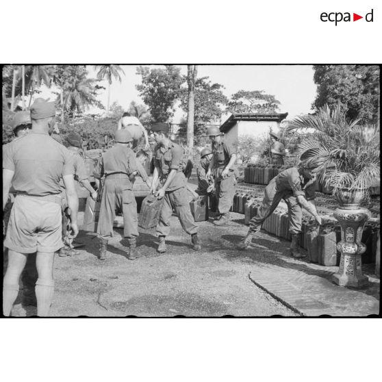 Déchargement du ravitaillement de jerricans d'essence par les soldats de la 2e division blindée à Tan An.