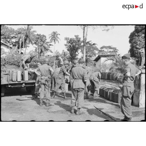 Déchargement du ravitaillement de jerricans d'essence par les soldats de la 2e division blindée à Tan An.