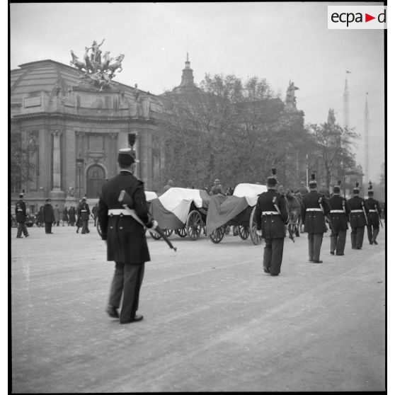 Le convoi des cercueils passe devant le grand palais.