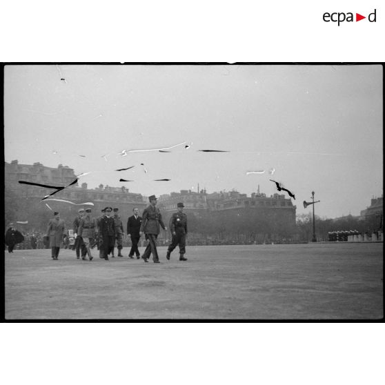 Le général De Gaulle et des officiers l'accompagnant place de l'Etoile.