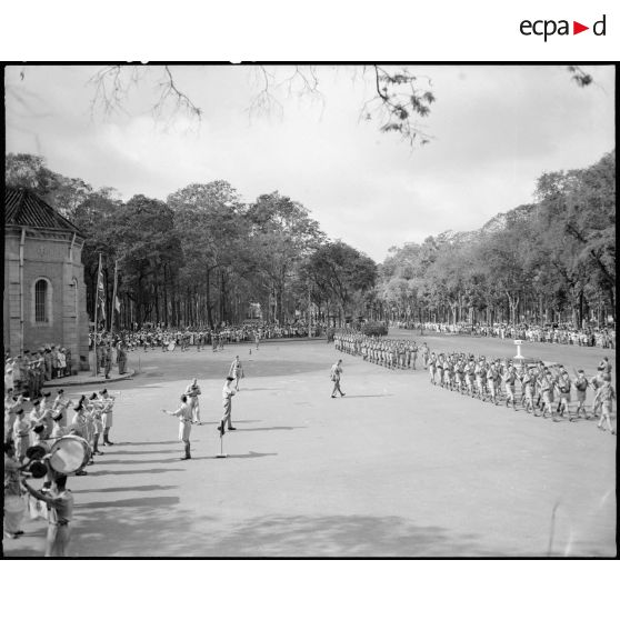 Défilé de troupes; sur la gauche, la fanfare.