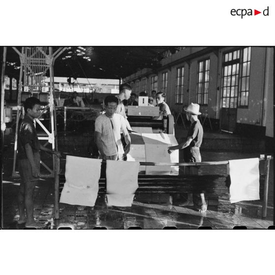 IINDUSTRIE . Travailleurs à l' intérieur de l' usine avec les premières feuilles de caoutchouc depuis la reprise de la plantation.