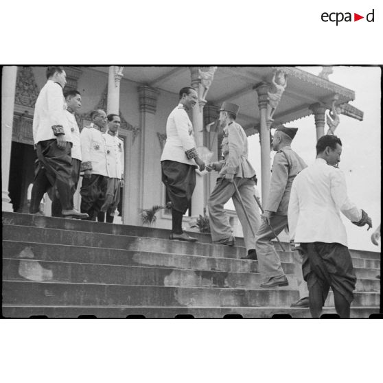 Le général LECLERC, suivi du général ALESSANDRI gravit les escaliers pour aller saluer le prince MONIVETH, premier ministre du roi du CAMBODGE.