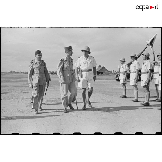 Arrivée du général LECLERC sur le terrain de PHNOM-PENH le 3 janvier 1946. Celui-ci est accueilli par le général ALESSANDRI, commissaire de la république. Il passe ensuite en revue les troupes constituant la haie d' honneur.