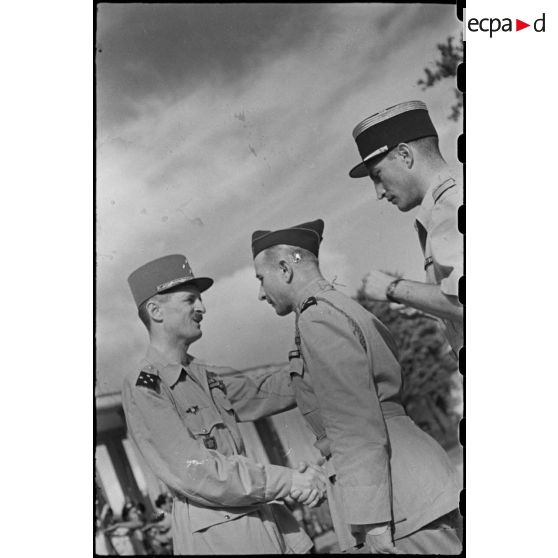 Décoration du général ALESSANDRI de la cravate de commandeur de la légion d' honneur par le général LECLERC puis lui serrant la main par la suite.