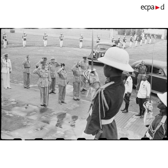 Le général LECLERC, le général ALESSANDRI et d' autres officiers au garde-à-vous pendant le salut aux couleurs.