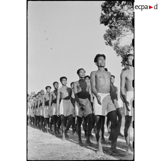 ENTRAINEMENT-MILITAIRE . Soldats cambodgiens en short, pieds nus pendant un exercice d' ordre serré.