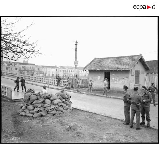 Sentinelles chinoises à l' entrée d' un pont. Les militaires français sont en discussion à côté.