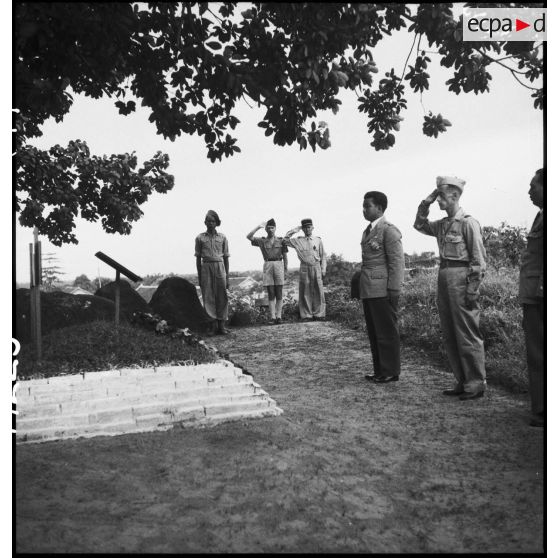 Sa majesté NORODOM SIHANUK, roi du CAMBODGE, entouré d' officiers français saluant devant le monument militaire français à KOMPONG-CHAM.