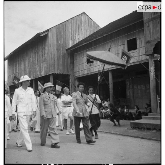 Sa majesté NORODOM SIHANUK roi du CAMBODGE dans une rue de PEAM-CHIKANG entouré d' officiers.