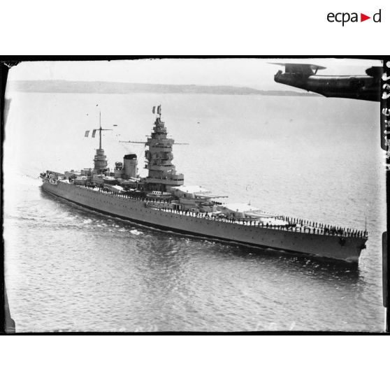 Vue aérienne du croiseur Dunkerque avec son équipage à la bande.